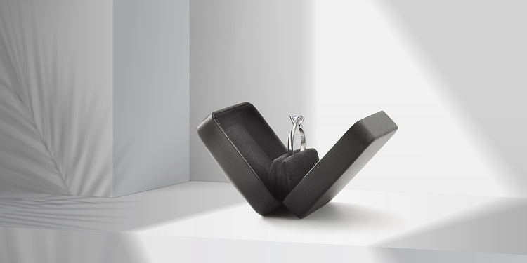 Eleganter Solitär-Verlobungsring aus Weißgold mit Diamant, präsentiert in einem modernen schwarzen Ringetui mit raffinierter Ring-Halterung vor minimalistischem weißem Hintergrund