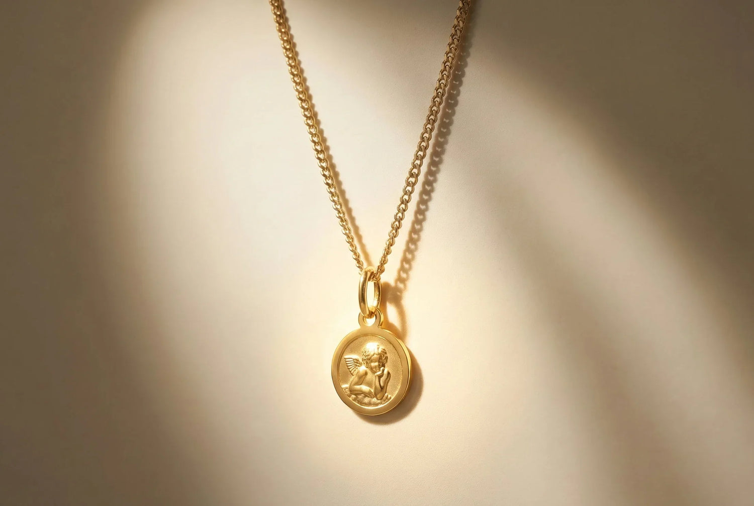 Goldene Halskette mit herzförmigem Schutzengel-Anhänger am Dekolleté getragen