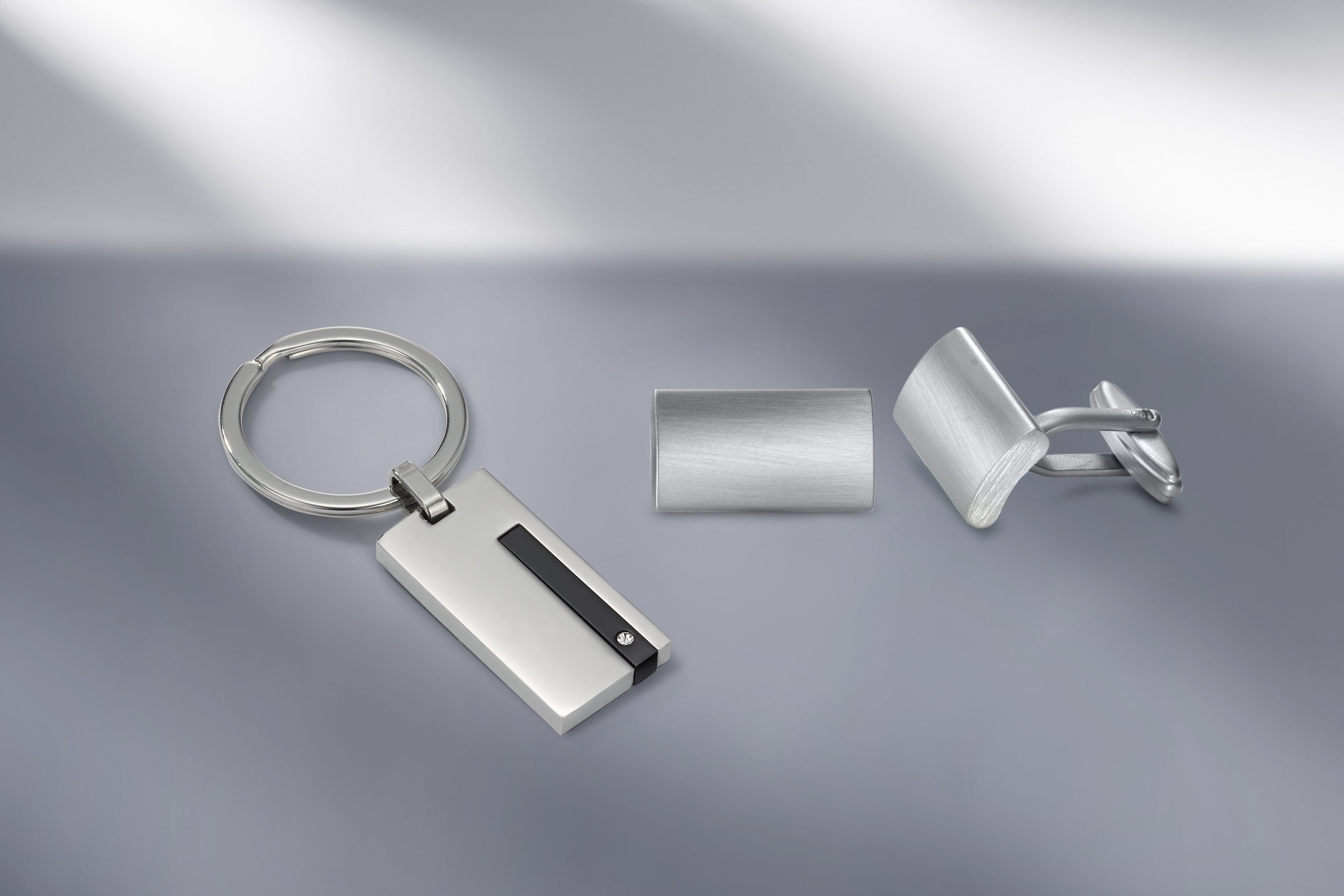 Elegante Herren-Accessoires aus Edelstahl: Schlüsselanhänger mit schwarzem Akzent, Krawattenklammer und rechteckige Manschettenknöpfe